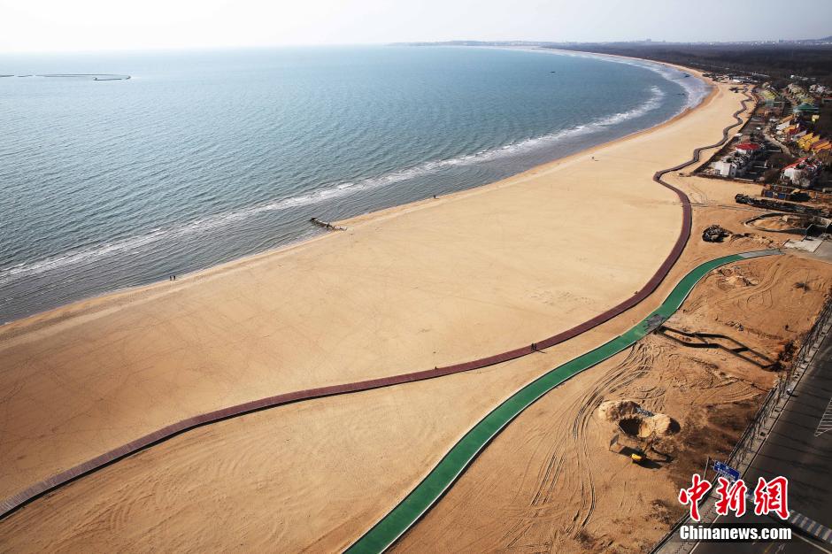 3月13日，秦皇島萬米臨海沙灘木棧道。據(jù)了解，該木棧道全長(zhǎng)約4200米，與北戴河區(qū)原有的7500米木棧道對(duì)接后全線總長(zhǎng)度1.17萬米，整個(gè)木棧道東起秦皇島體育基地游船碼頭，西至北戴河濕地公園，呈波浪形蜿蜒10.4公里海岸線。 中新社發(fā) 曹建雄 攝 CNSPHOTO